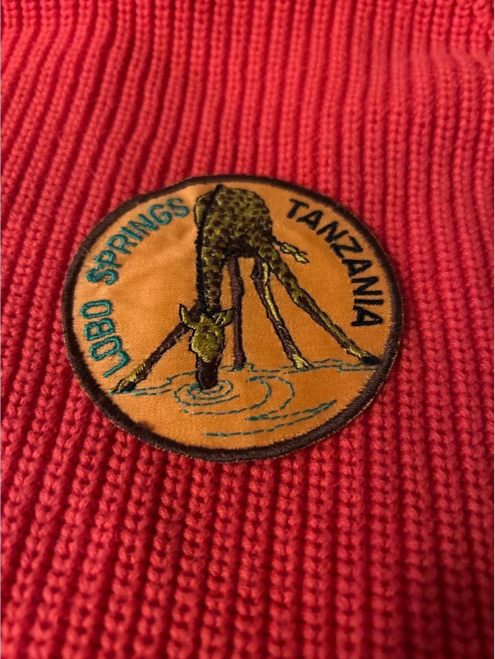 Tanzania Lobo Springs Embroidered Patch on Red Knit Fabric